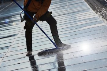 Technician Is Using A Mop And Water To Clean The Solar Panels That Are Dirty With Dust And Birds' Droppings To Improve The Efficiency Of Solar Energy Storage Even Better. Soft And Selective Focus.